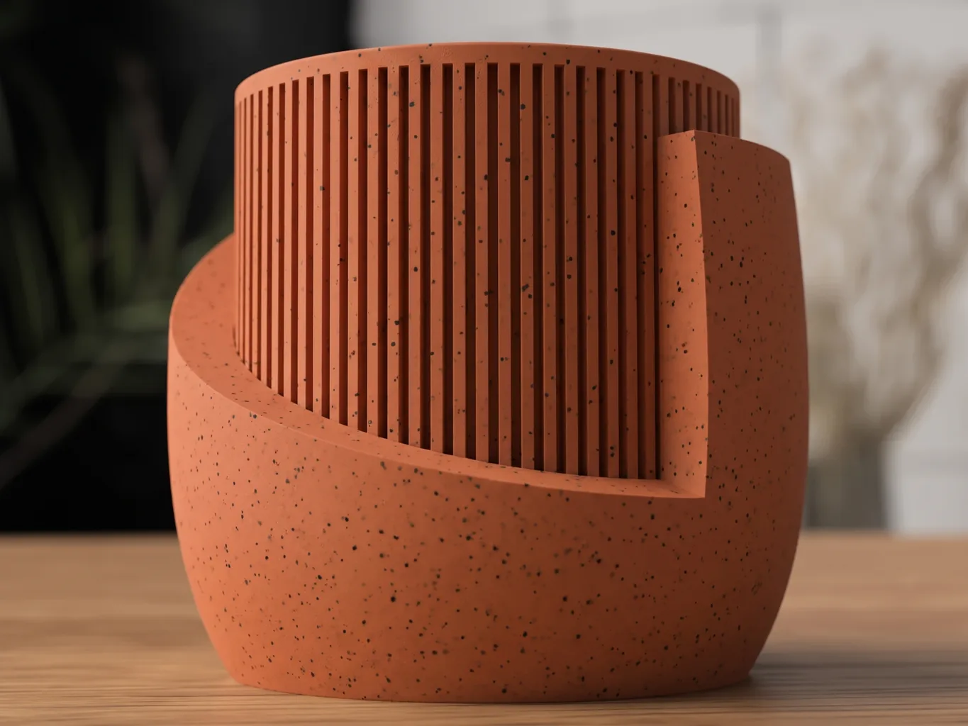 3D-gedruckter Übertopf Sekiya in gesprenkeltem Terrakotta, äußere Schale spiralförmig skulptiert, aus der ein gerippter innerer Zylinder hervorragt, auf Holztisch